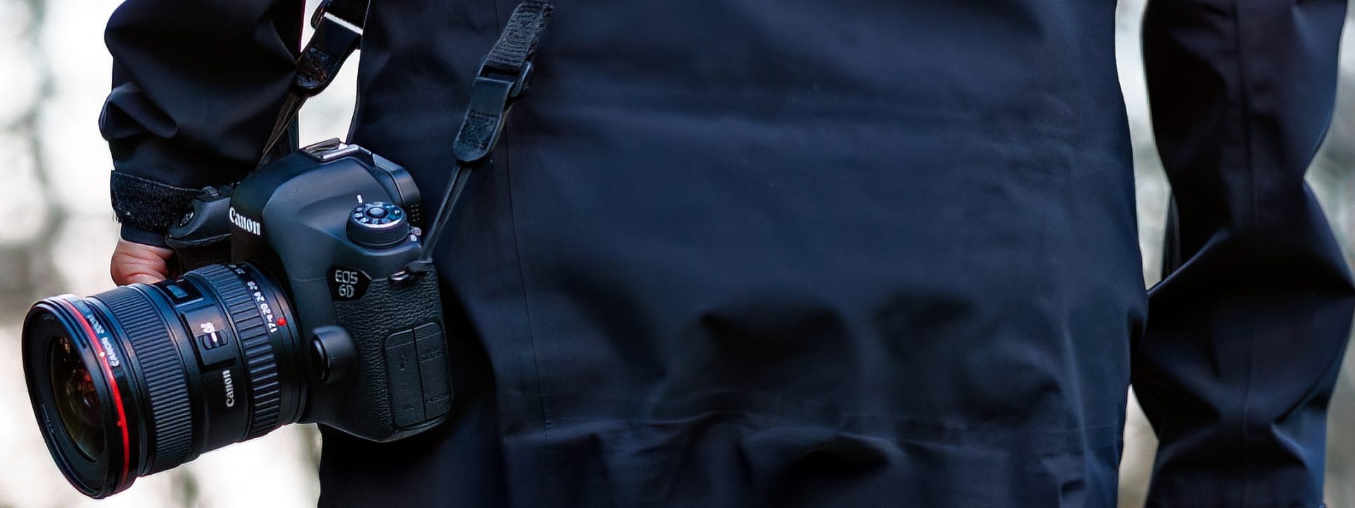 Photographe tenant un Canon EOS 6D plein format en bandoulière appareil qui a marqué son apprentissage du numérique.