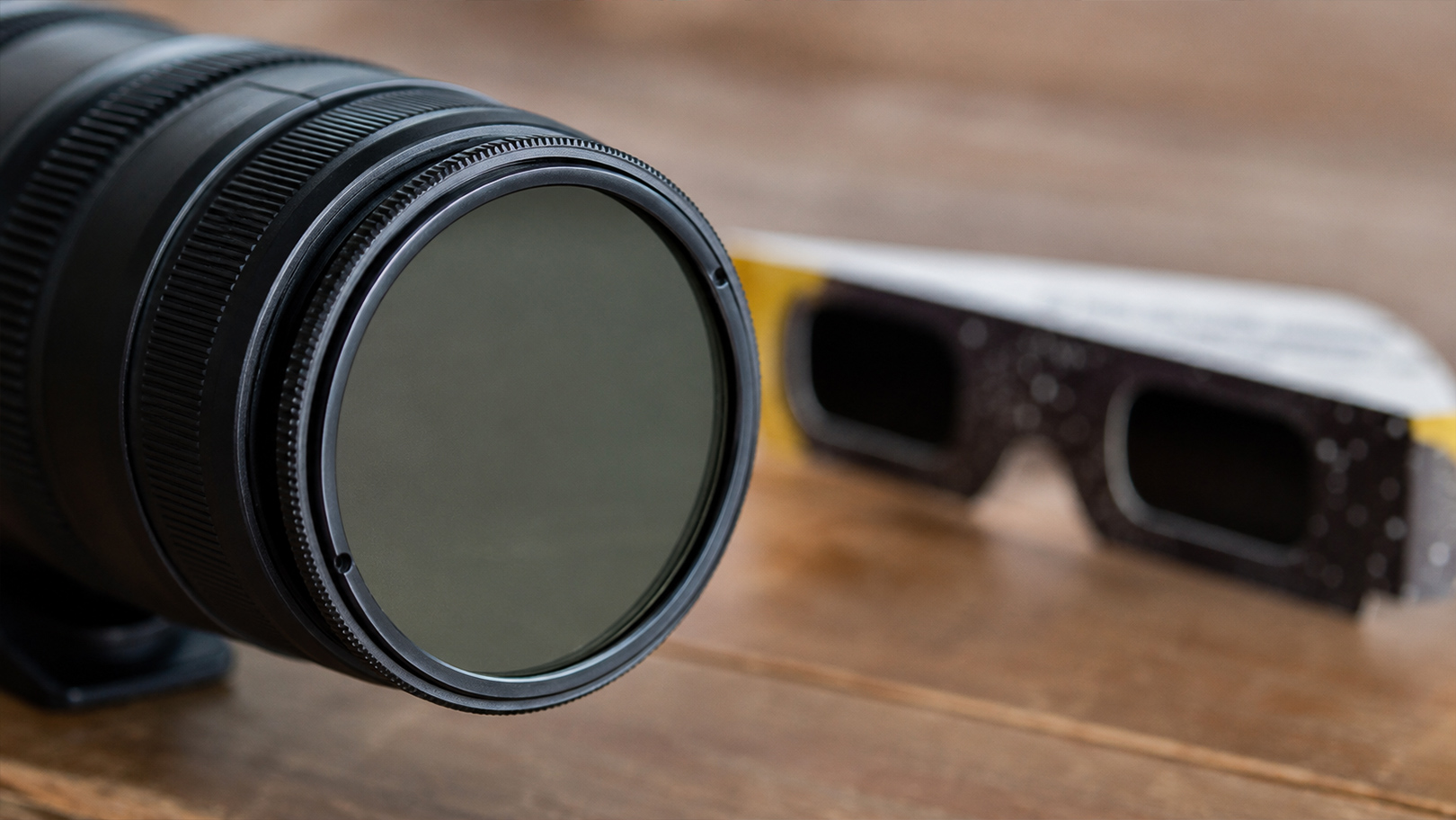 Filtre solaire certifié installé devant un objectif de téléobjectif pour photographier une éclipse