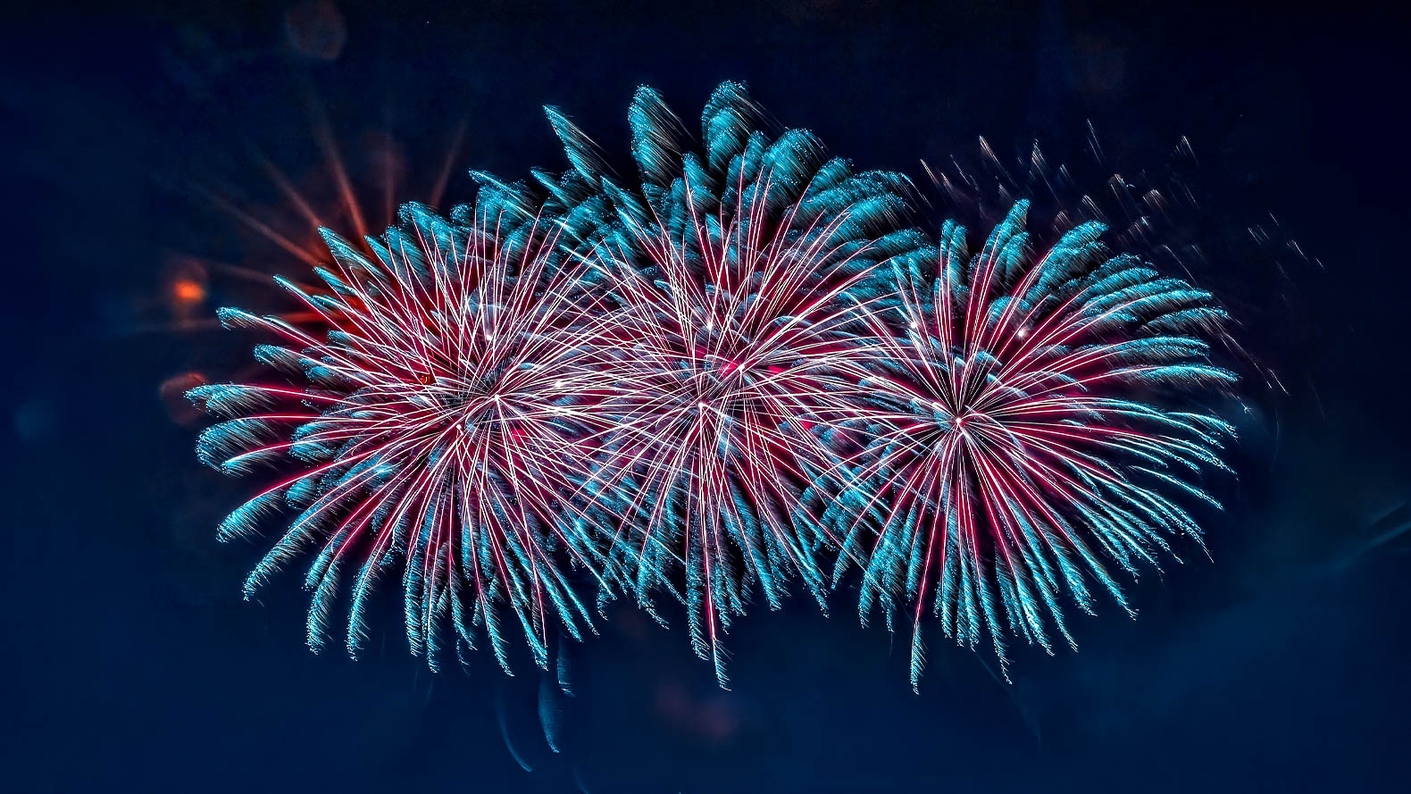 Feux d’artifice photographiés de nuit avec longues traînées lumineuses colorées