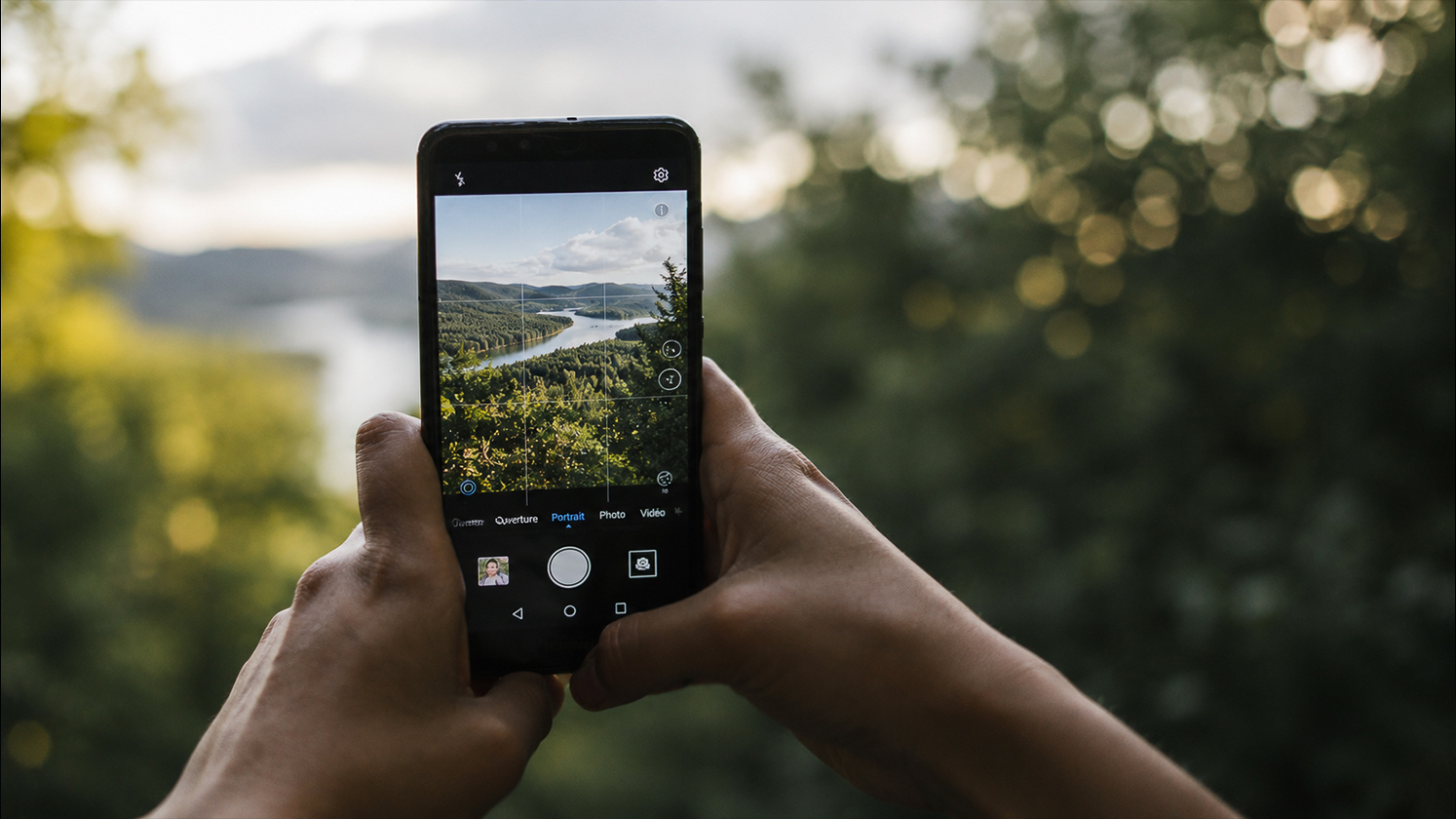 Personne composant une photo avec un smartphone en extérieur